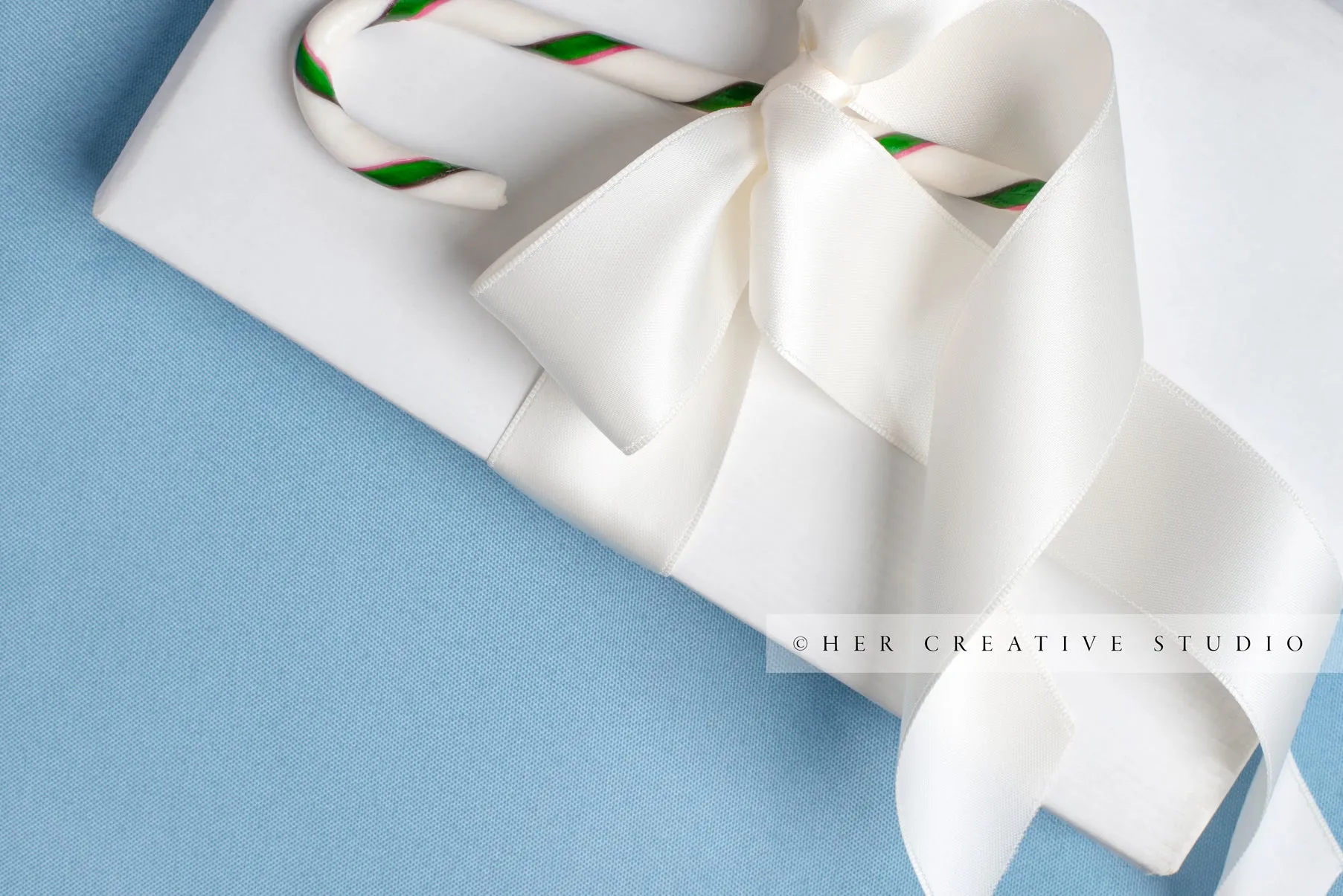 Holiday Gift with Candy Cane on Sky Blue Background