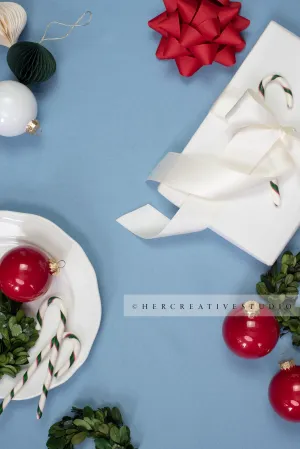 Red Ornaments, Holiday Gift & Wreath on Sky Blue Background